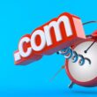 Kırmızı bir çalar saatten yaylarla fırlayan .com domain uzantısı, alan adı tescilinin aciliyetini ve doğru zamanlamanın önemini simgeliyor.
