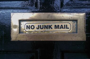 Siyah bir kapıdaki metal posta kutusunun üzerinde, spam mail engellemeyi simgeleyen "NO JUNK MAIL" (İstenmeyen Posta Yok) uyarısı bulunuyor.