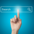 Elasticsearch'ün (Esnek Arama) metin arama ve sorgulama yeteneğini gösteren bir parmak, parlak mavi bir ekrandaki arama çubuğuna dokunarak Big Data içinde arama işlemini başlatıyor.