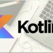 Kotlin programlama dilinin logosu, mobil uygulama geliştirme için kullanılan bir dizüstü bilgisayarın yanında, yeni başlayanlar için bir öğrenme ortamını temsil ediyor.